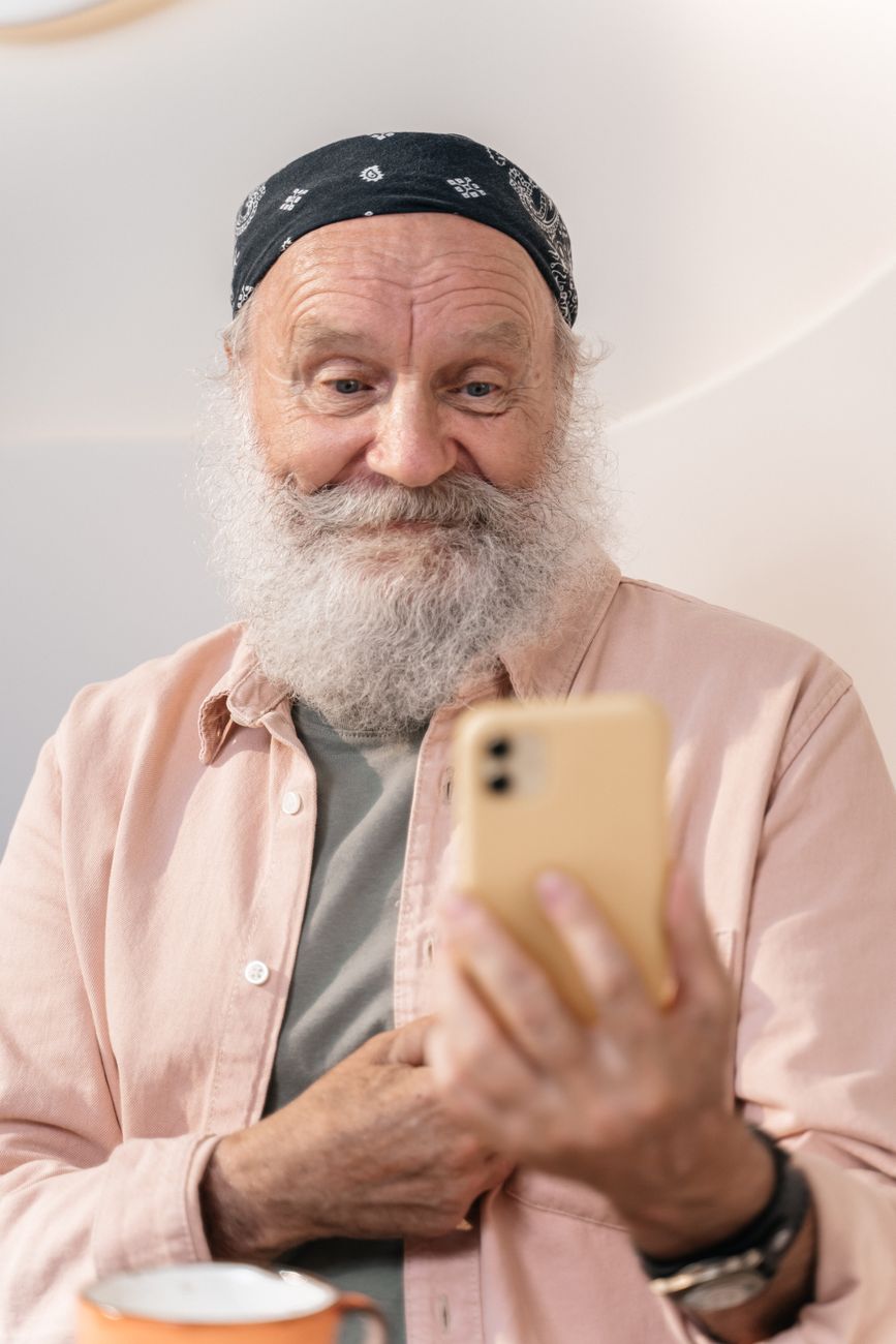 Senior man smiling at his phone